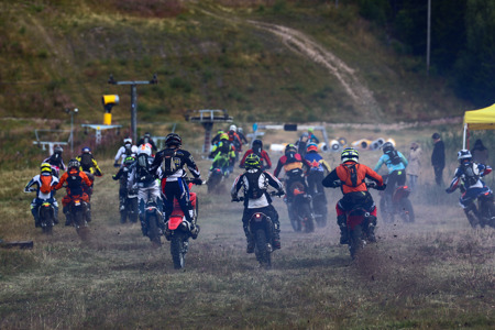 Flera personer kör motocross på en gräsbana och startar samtidigt.